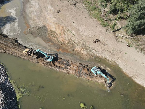 Luftaufnahme der March mit wieder angebundenen Flussarmen in der bewaldeten Auenlandschaft. Zwei Bagger vertiefen einen Flussarm.