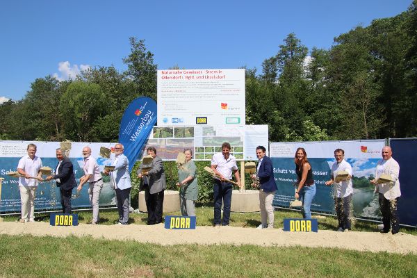 Zusehen ist die Spatenstichfeier für die Renaturierung der Strem in Ollersdorf – Litzelsdorf. Auf den Bild zu sehen ist, von links: Christian Sailer (Landeswasserbau), Wolfgang Wukovits (Wasserbauamt), Bürgermeister Bernd Strobl (Ollersdorf), Sectionschefin Monika Mörth (Bundesministerium für Land- und Forstwirtschaft, Klima- und Umweltschutz, Regionen und Wasserwirtschaft), Bürgermeister Jürgen Resch (Litzelsdorf). Alle abgebildeten Personen führen gemeinsam einen symbolischen Spatenstich durch und werfen dabei Erde mit ihren Spaten in die Luft.