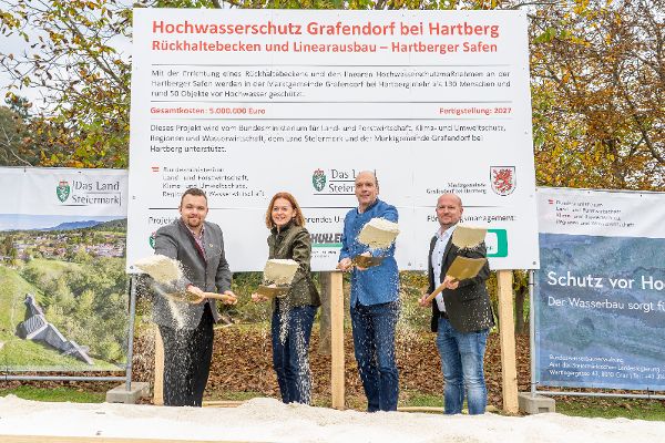 Foto vor der Bautafel des Hochwasserschutz Grafendorf.