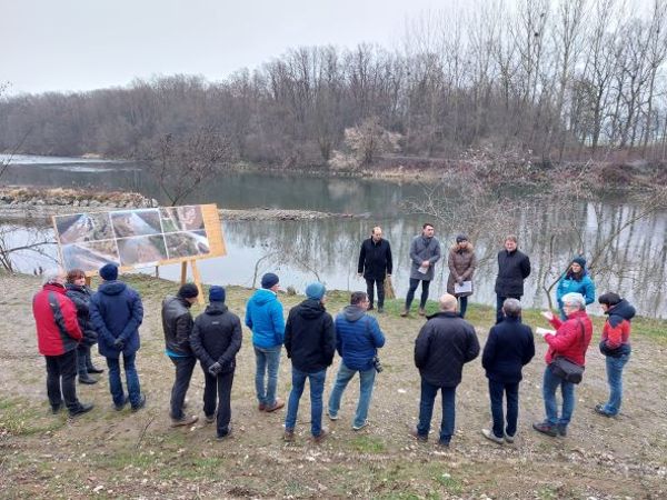 mehrere Personen stehen in einen Halbkreis vor Schautafeln der umliegenden Landschaft