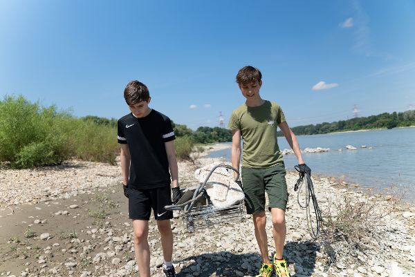 Schüler beim Müllsammeln entlang der Donau.