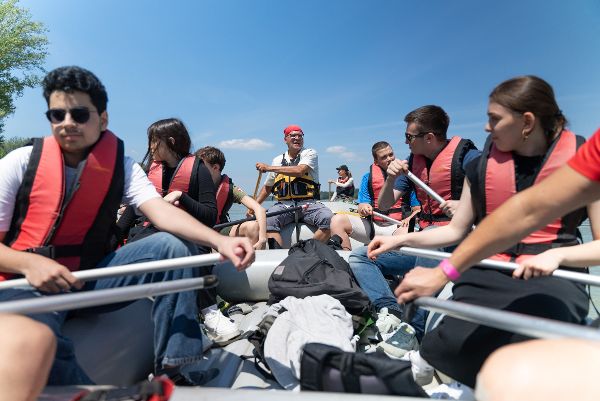 Schülerinnen und Schüler beim Paddeln in einem Schlauchboot.