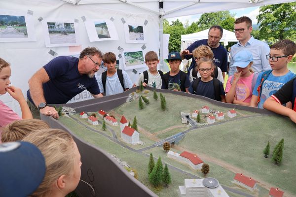 Wassererlebnistag beim Bürgerausee in Kuchl, Salzburg Landesrat Maximilian Aigner beim Besuch der Veranstaltung Im Bild mit Schülern bei einer Vorführung zum Thema Hochwasserschutz 2.7.2026