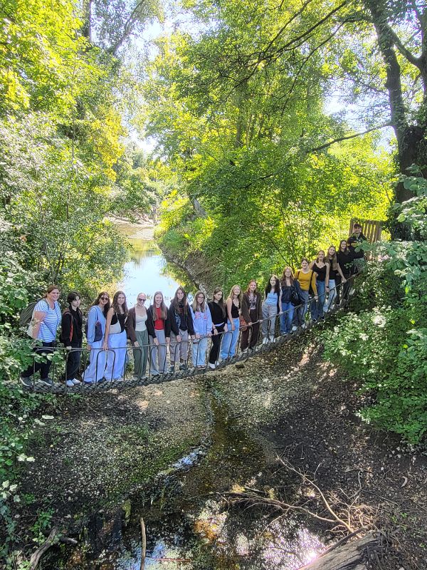 Schulklasse beim Gruppenfoto auf einer Hängebrücke im Nationalpark Donau-Auen.