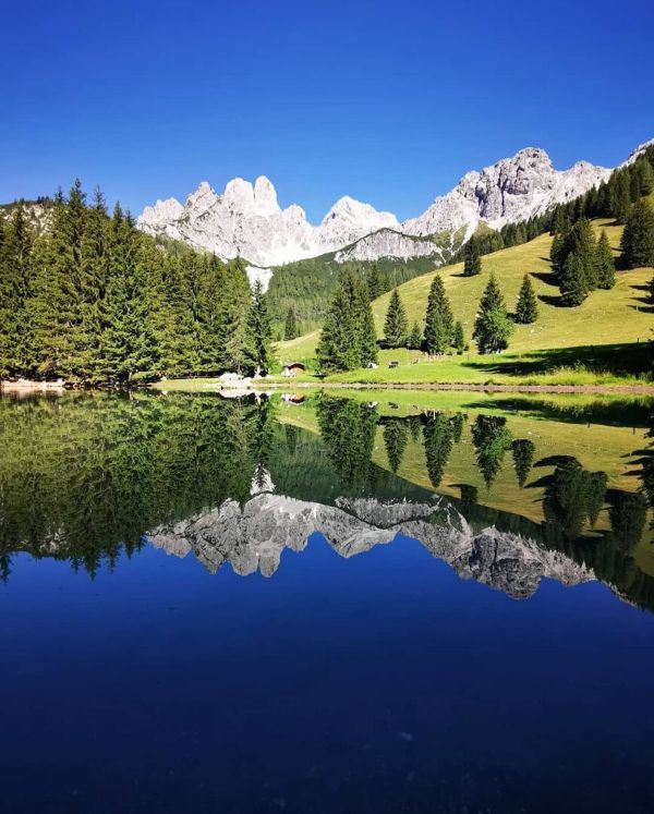 Zu sehen ist ein See in dem sich ein Berg spiegel.