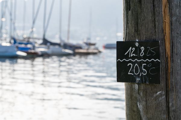 Wassertemperaturanzeige bei einem See mit Booten.