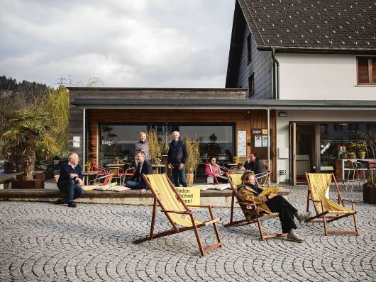 Sonnenliegen stehen am verkehrsfreien Dorfplatz