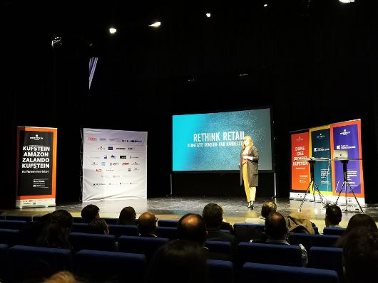 Zu sehen ist eine Frau auf der Bühne bei der Abschlussveranstaltung des Projekts.