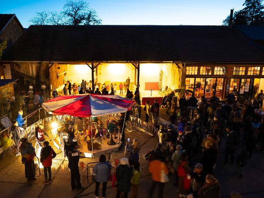 Auf dem Bild ist ein reges Treiben am Dorfplatz zusehen.
