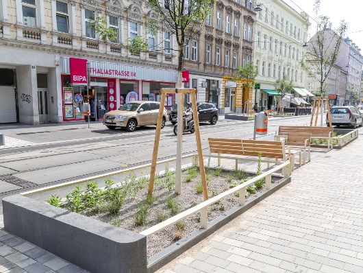 Zu sehen ist der neu ausgebaute Klimaboulevard Thaliastraße samt Bänke und Begrünung.