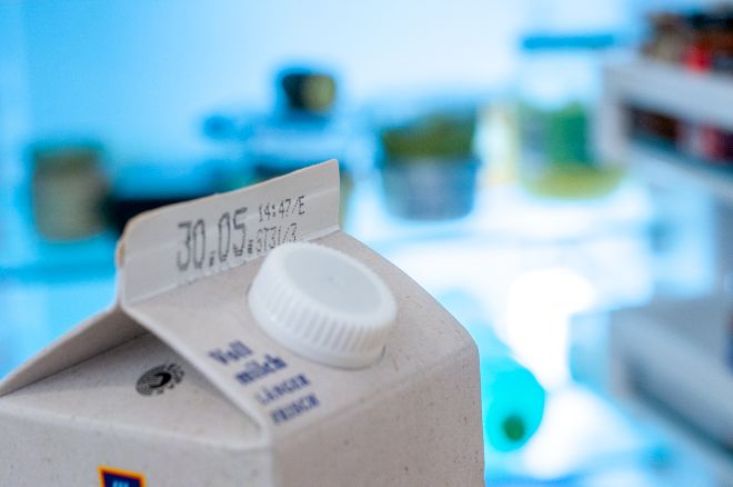 Milchpackung vor einem Kühlschrank, das Mindesthaltbarkeitsdatum zeigt den 30.5.