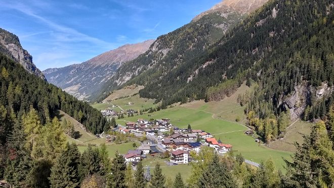 Landschaft mit einem Tal mit Siedlungen, links und rechts umgeben von steilen Bergen mit Schutzwald