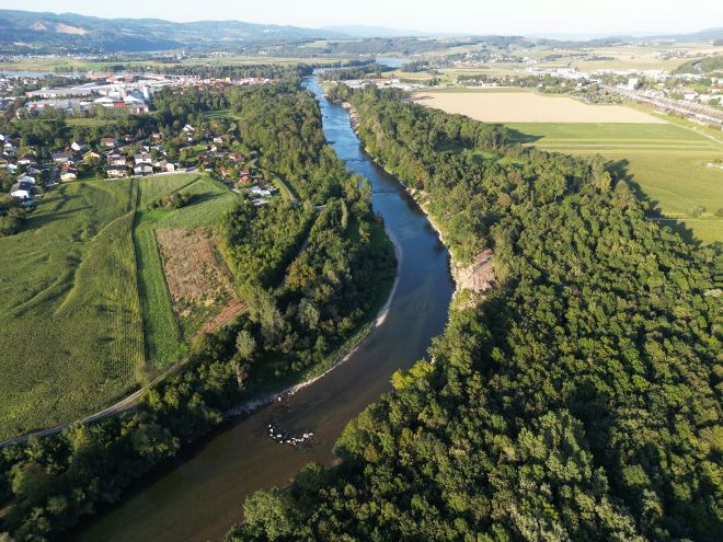 Fluss schlaengelt sich durch eine gruene Landschaft