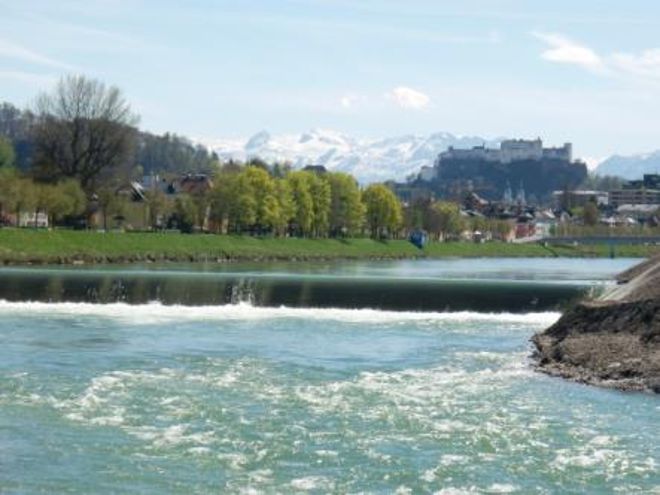 Vor dem Salzburger Panorama sieht man eine die Salzach durchquerende Sohlstufe