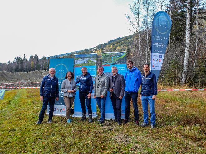 Delegation des Wasserbaues vor Bautafeln