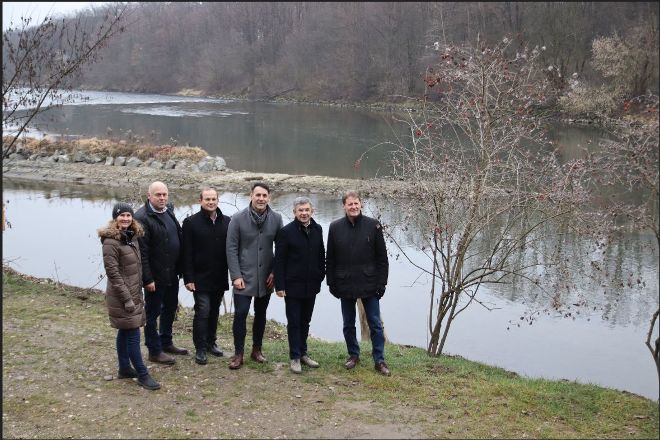 sechs gut gekleidete Personen vor einem FLuss