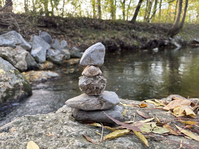 Eine Fotografie einer Steinfigur vor einem kleinen Fluss. 